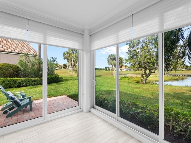 unfurnished sunroom featuring a water view