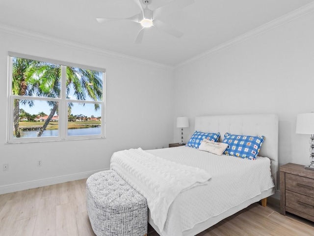 bedroom featuring ceiling fan, ornamental molding, and light wood-type flooring