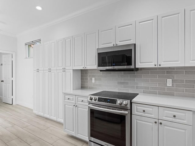 kitchen with white cabinetry, appliances with stainless steel finishes, and decorative backsplash