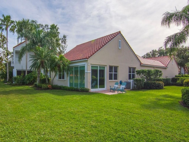 back of house featuring a patio and a yard