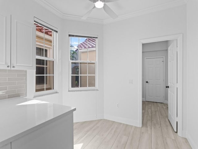 interior space with crown molding, light hardwood / wood-style flooring, and ceiling fan