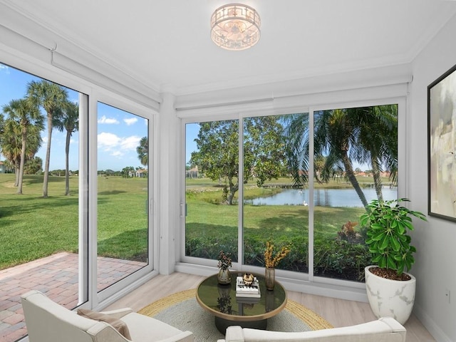 sunroom featuring a water view