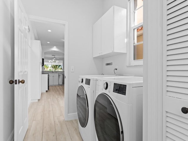 laundry area with independent washer and dryer, cabinets, ceiling fan, and light hardwood / wood-style flooring