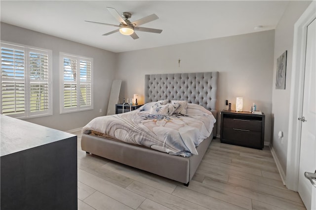 bedroom with light hardwood / wood-style floors and ceiling fan