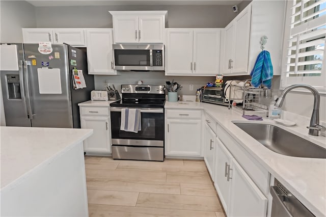 kitchen with white cabinetry, light wood-type flooring, sink, and stainless steel appliances