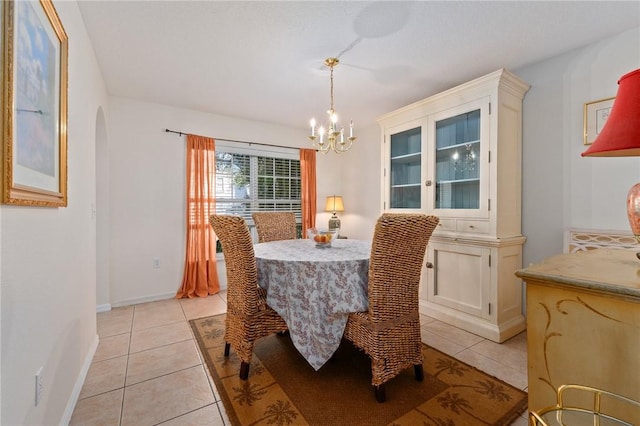 dining area featuring light tile patterned flooring and a notable chandelier