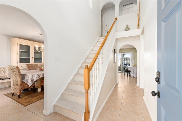 stairs featuring an inviting chandelier and tile patterned floors