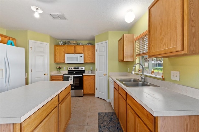 kitchen featuring sink, white appliances, light tile patterned floors, a textured ceiling, and a kitchen island