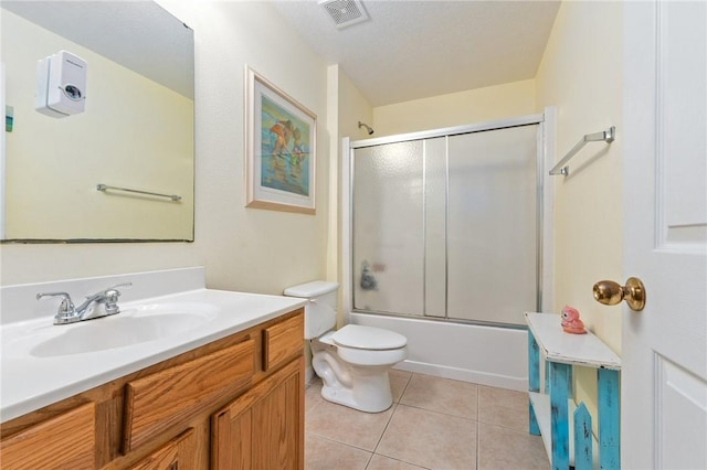 full bathroom featuring vanity, tile patterned floors, enclosed tub / shower combo, and toilet