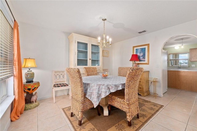 tiled dining area featuring an inviting chandelier and sink