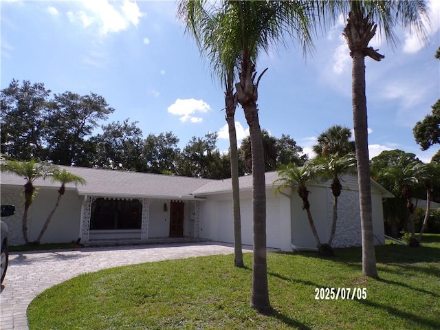 881 48th Ave, Vero Beach, FL 32966 - ranch-style home with curved driveway, a front yard, and an attached garage