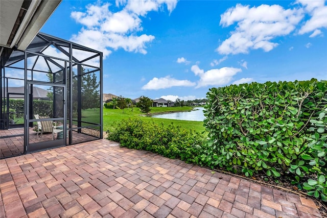 view of patio with a water view and glass enclosure