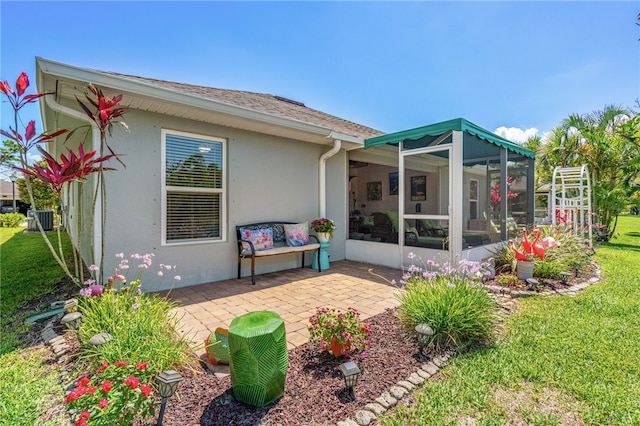 439 Briarcliff Cir, Sebastian, FL 32958 - back of house featuring stucco siding, a sunroom, a patio area, a yard, and central AC