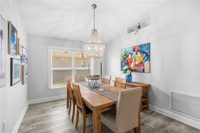 439 Briarcliff Cir, Sebastian, FL 32958 - dining area with a chandelier, wood finished floors, baseboards, and vaulted ceiling