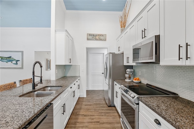 1368 Scroll St, Sebastian, FL 32958 - kitchen with appliances with stainless steel finishes, ornamental molding, dark stone countertops, and white cabinetry
