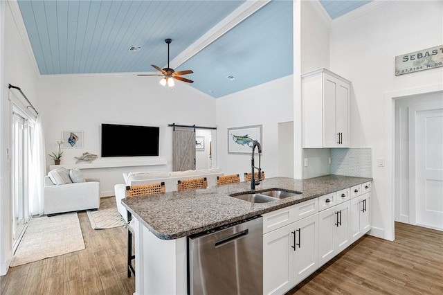 1368 Scroll St, Sebastian, FL 32958 - kitchen featuring stainless steel dishwasher, ornamental molding, a peninsula, dark stone countertops, and light wood-style flooring