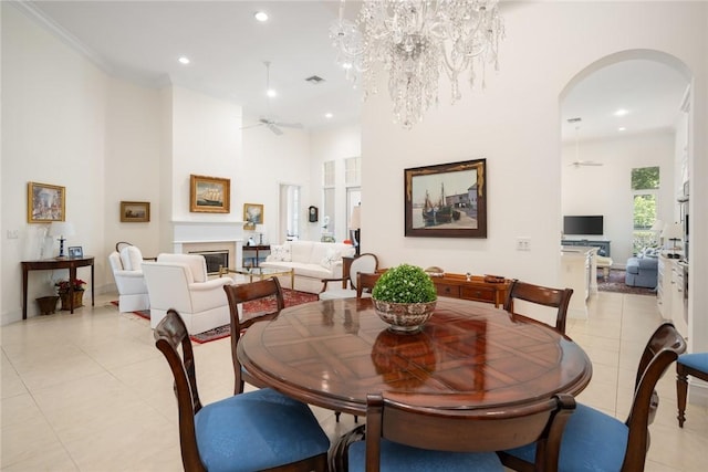 1624 Weybridge Cir, Vero Beach, FL 32963 - dining space featuring ceiling fan with notable chandelier, arched walkways, a glass covered fireplace, recessed lighting, and light tile patterned flooring