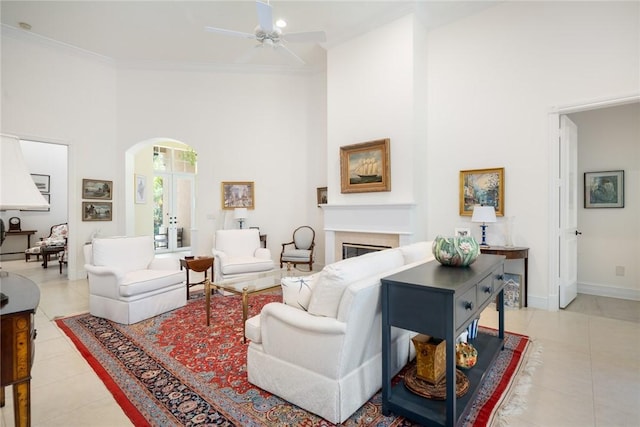 1624 Weybridge Cir, Vero Beach, FL 32963 - living room with a glass covered fireplace, arched walkways, a towering ceiling, and a ceiling fan