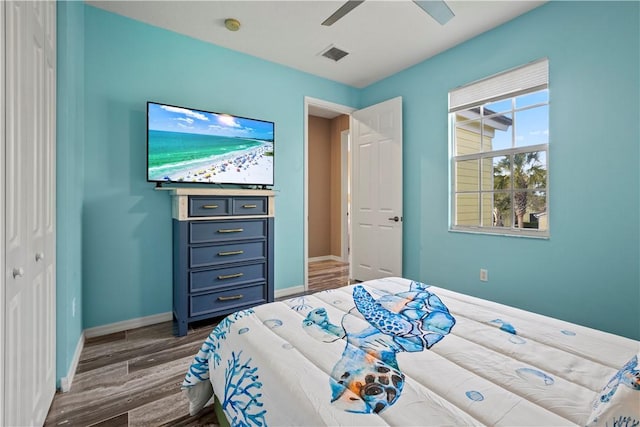 bedroom featuring dark wood-type flooring, ceiling fan, and a closet