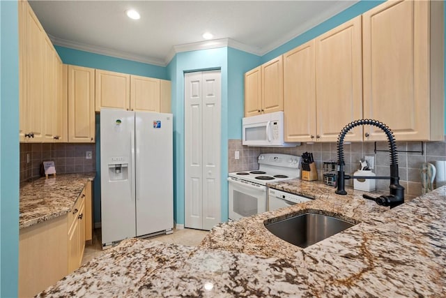 kitchen with ornamental molding, light stone countertops, sink, and white appliances