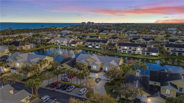 aerial view at dusk featuring a water view