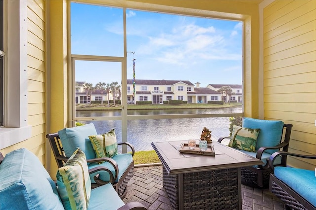 sunroom / solarium featuring a water view and a healthy amount of sunlight