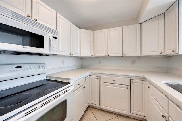 855 Dahlia Ln Unit 304, Vero Beach, FL 32963 - kitchen with white appliances, white cabinets, light tile patterned floors, and light countertops