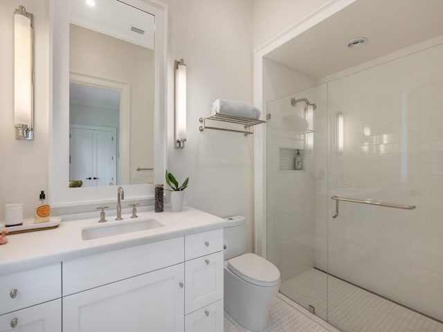 bathroom featuring vanity, a shower stall, toilet, and visible vents