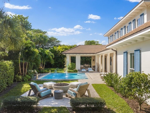 outdoor pool with an outdoor living space with a fire pit and a patio area