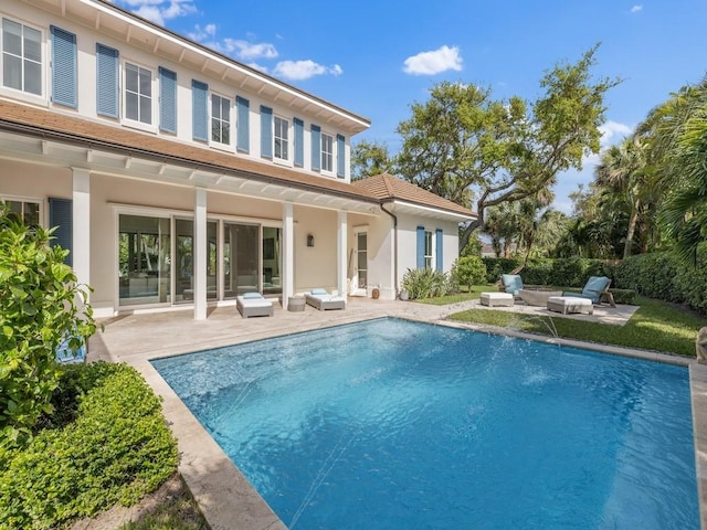 back of house with a fenced in pool, a patio, and stucco siding