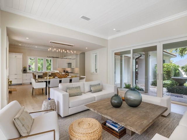 living area with light wood-type flooring, visible vents, ornamental molding, recessed lighting, and a chandelier