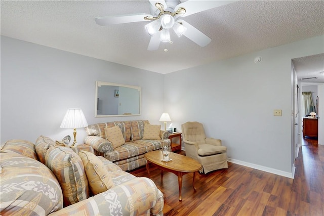 living room with ceiling fan, dark hardwood / wood-style floors, and a textured ceiling