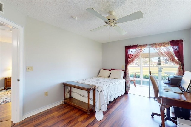 bedroom featuring access to exterior, dark hardwood / wood-style floors, and a textured ceiling