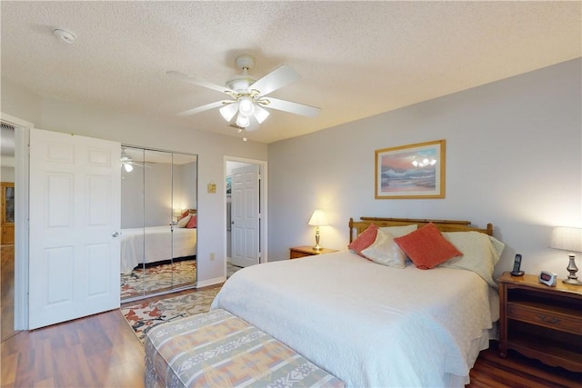 bedroom featuring hardwood / wood-style flooring, ceiling fan, a closet, and a textured ceiling