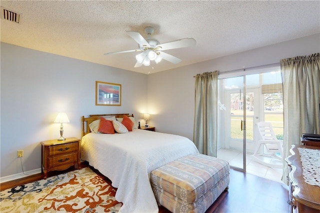 bedroom featuring ceiling fan, hardwood / wood-style floors, a textured ceiling, and access to outside