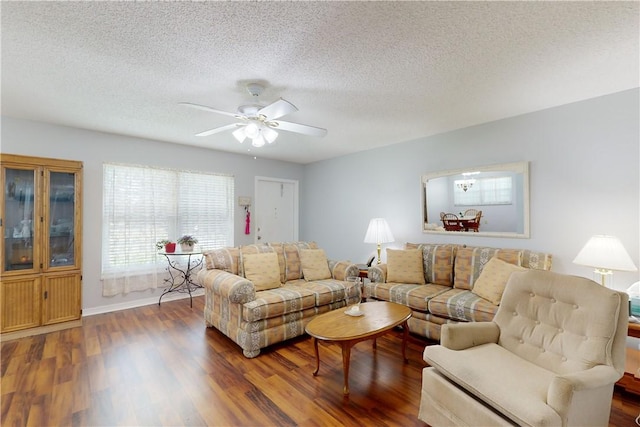 living room featuring dark hardwood / wood-style flooring, a textured ceiling, and ceiling fan