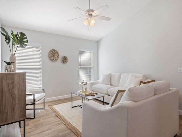 living room featuring light hardwood / wood-style floors, ceiling fan, and vaulted ceiling