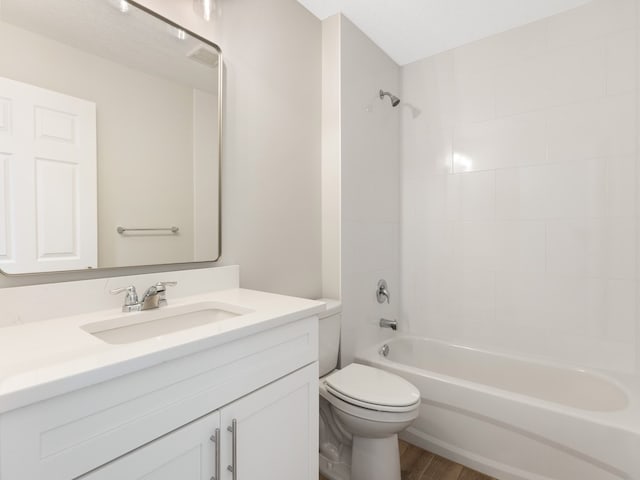 full bathroom featuring hardwood / wood-style flooring, tiled shower / bath, a textured ceiling, vanity, and toilet