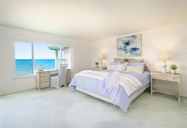 8830 S Sea Oaks Way Unit 301, Vero Beach, FL 32963 - bedroom featuring light carpet, a water view, and a textured ceiling