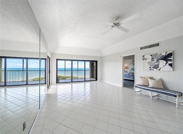 8830 S Sea Oaks Way Unit 301, Vero Beach, FL 32963 - spare room with a textured ceiling, light tile patterned floors, ceiling fan, and a water view