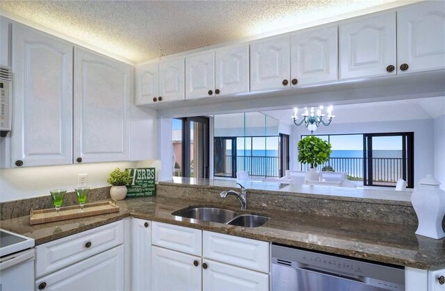 8830 S Sea Oaks Way Unit 301, Vero Beach, FL 32963 - kitchen featuring stainless steel dishwasher, white cabinets, and a textured ceiling
