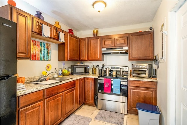 kitchen featuring sink, light tile patterned floors, black refrigerator, electric range, and light stone countertops