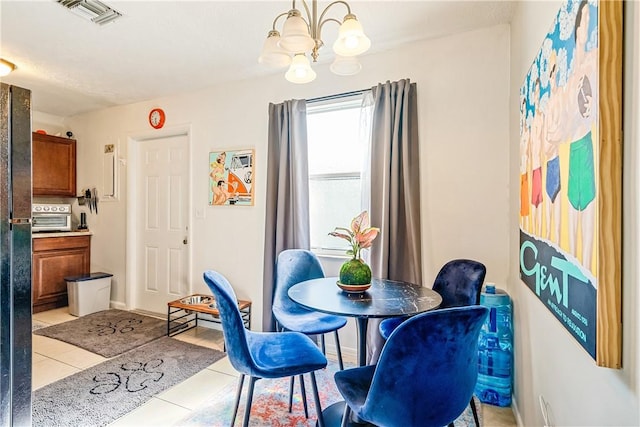 tiled dining room with a chandelier