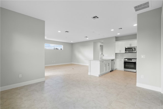 unfurnished living room with light tile patterned floors and sink