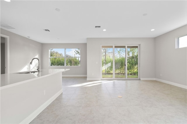 interior space with plenty of natural light, light tile patterned floors, and sink