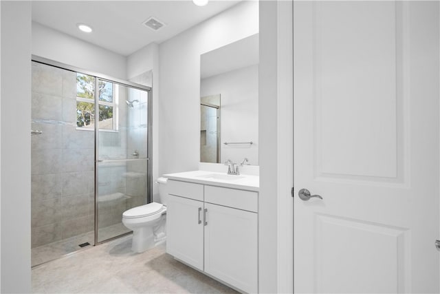 bathroom with vanity, toilet, and a shower with shower door