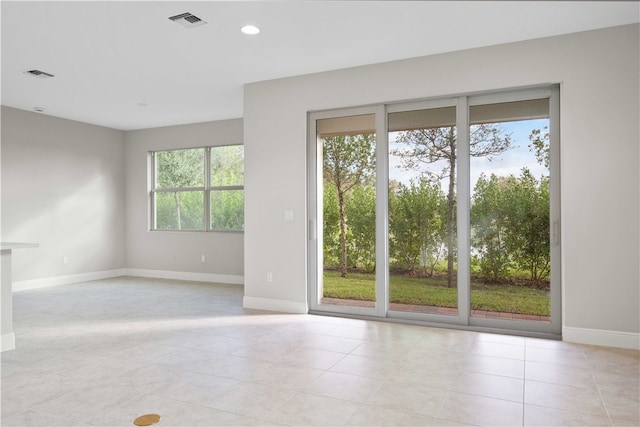 spare room featuring a healthy amount of sunlight and light tile patterned flooring