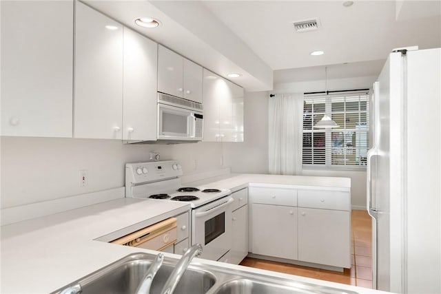 5540 N Harbor Village Dr Unit 103, Vero Beach, FL 32967 - kitchen featuring white cabinetry, light countertops, white appliances, and visible vents