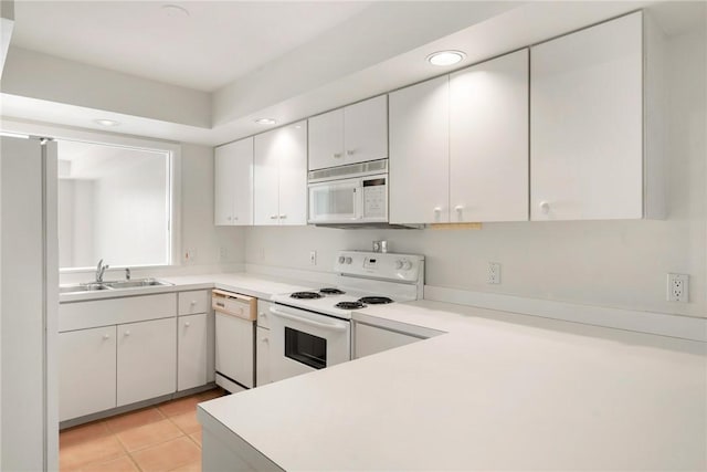5540 N Harbor Village Dr Unit 103, Vero Beach, FL 32967 - kitchen featuring light tile patterned floors, a sink, light countertops, white appliances, and white cabinetry
