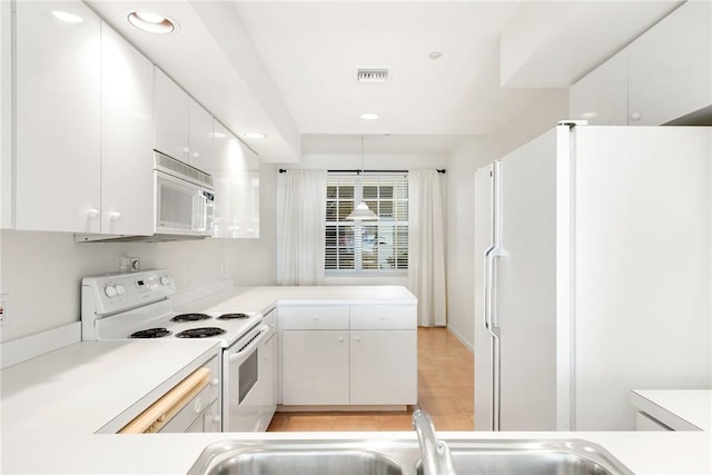 5540 N Harbor Village Dr Unit 103, Vero Beach, FL 32967 - kitchen with a peninsula, light countertops, white appliances, and white cabinets